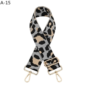 Macro view of leopard print bag strap with golden metal swivel hooks and buckle
