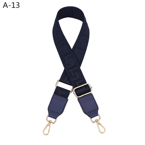 Close-up of adjustable blue geometric pattern bag strap with gold metal hooks and leather ends