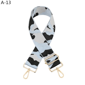 Macro shot of adjustable bag strap with blue cow print and gold metal buckles