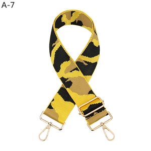 Detailed view of wide camo nylon bag strap with polished gold-tone metal lobster clasps