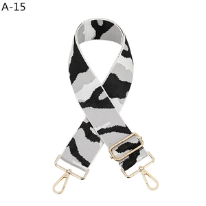 Detail of adjustable camouflage bag strap with durable canvas and gold metal hooks