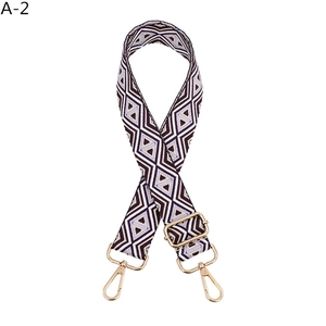 Detail of adjustable geometric diamond pattern bag strap with gold metal spring hooks
