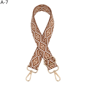 Detail view of brown and white geometric diamond pattern strap with golden metal clasps