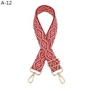 Adjustable bag strap featuring red and white geometric diamond pattern with gold hooks