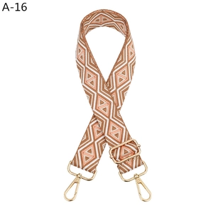 Detail view of woven bohemian geometric strap with gold metal hooks and adjustable buckle