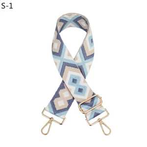 Detail view of woven diamond pattern bag strap with polished gold-tone lobster clasps