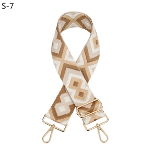 Detail of bohemian geometric pattern on adjustable wide bag strap with gold metal hardware