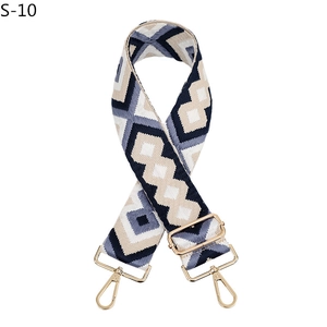 Close-up of diamond pattern woven bag strap with polished gold-tone hardware hooks