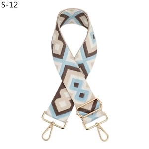 Detail view of ethnic geometric diamond pattern shoulder strap with gold metal hooks