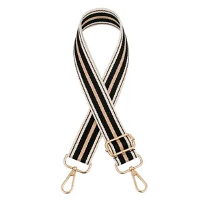 Detail of adjustable black, white and beige striped canvas strap with gold metal hooks