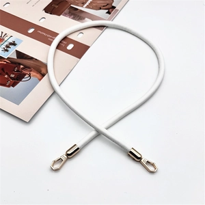 Detail of white PU leather cylindrical handbag strap with golden hexagonal lobster clasps