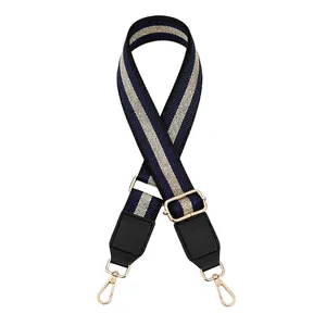Close-up of woven adjustable shoulder strap with navy stripes and gold lobster clasps