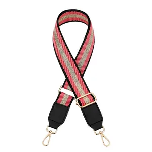 Detail of adjustable pink and black striped woven strap with gold metal hooks