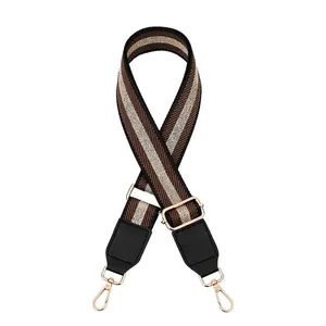 Adjustable woven strap with brown beige stripes and gold metal swivel snap hooks