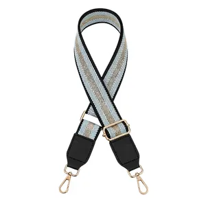 Detail of adjustable blue and gold striped woven strap with gold metallic swivel snap hooks