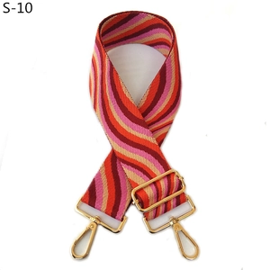 Detail of adjustable woven bag strap with pink and orange wave pattern and gold hooks