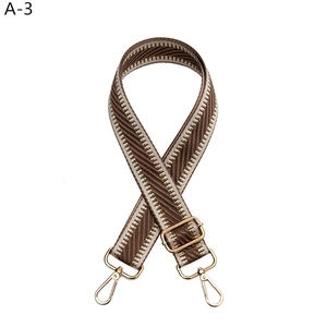 Close-up of herringbone adjustable woven bag strap with golden lobster clasps and hardware