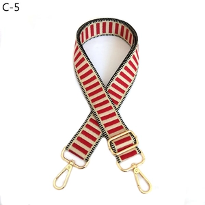 Detail of adjustable red and white striped wide shoulder strap with gold metal hooks