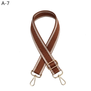 Detail of adjustable brown and white chevron woven strap with golden lobster clasps