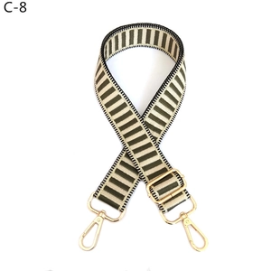 Detail of adjustable military green and beige striped fabric strap with gold hardware