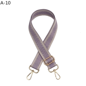 Detail of purple-grey herringbone woven strap with golden adjustable metal buckle