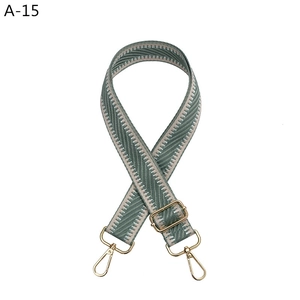 Macro detail of adjustable grey-green herringbone strap with gold metal lobster clasps