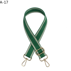 Detail of adjustable green and white wavy pattern bag strap with gold metal hardware