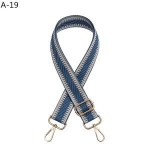 Detail of adjustable blue and beige herringbone strap with gold-tone swivel lobster clasps
