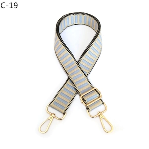 Detail of adjustable woven bag strap with blue and beige stripes and gold lobster clasp