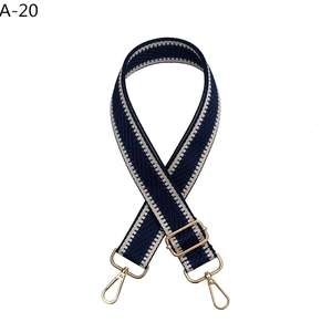 Close-up of dark blue and beige wavy woven strap with golden lobster clasps