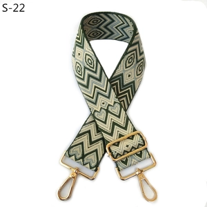Close-up of heart pattern on wide adjustable crossbody bag strap with gold metal hooks