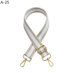Close-up of adjustable woven shoulder strap with gold metal buckles and herringbone pattern