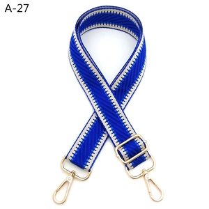 Macro detail of royal blue adjustable woven shoulder strap with gold metal buckles