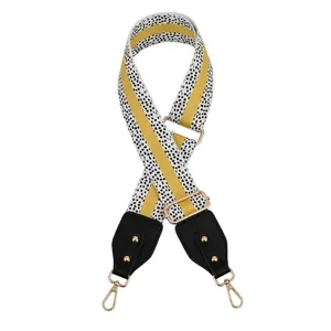 Adjustable yellow and black patterned fabric shoulder strap with gold metal hooks and leather
