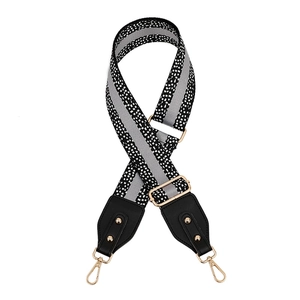 Adjustable black and white patterned bag strap with gold rivets and lobster clasps