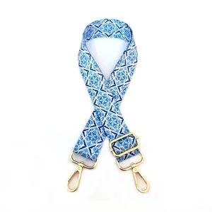 Detail of adjustable bag strap with blue vintage floral pattern and gold metal hooks