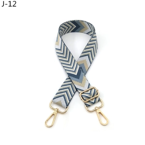 Close-up of adjustable woven shoulder strap with blue V-pattern and gold metal hooks