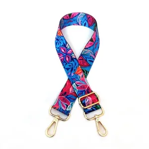 Detailed view of adjustable wide shoulder strap with vibrant floral print and gold metal clips