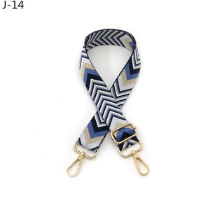 Detail view of adjustable geometric V-pattern shoulder strap with golden metal swivel hooks