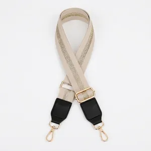 Close-up of adjustable beige strap with gold stripes and high-quality lobster clasps
