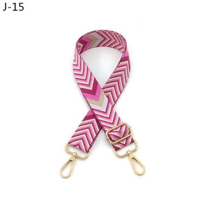 Close-up of adjustable woven shoulder strap with pink wave pattern and gold metal hooks