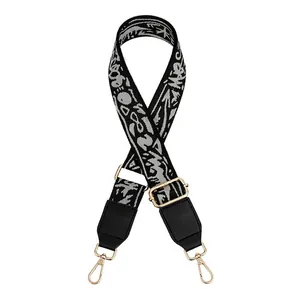 Detail view of adjustable jacquard bag strap with gold metal hooks and graffiti pattern