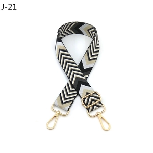 Detail of adjustable woven diamond pattern purse strap with gold metal hooks and buckle