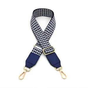 Adjustable crossbody strap featuring navy blue and white houndstooth pattern and gold hooks
