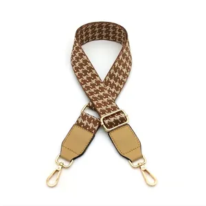 Adjustable brown and beige houndstooth pattern bag strap with gold metal hooks