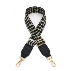 Adjustable houndstooth woven strap with black PU leather ends and gold metal hooks