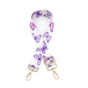 Detail of adjustable bag strap with purple butterfly print and gold lobster clasps