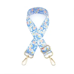 Detail of blue daisy floral bag strap with gold metal buckles and adjustable slider
