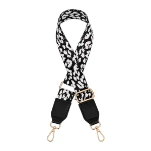 Detail of adjustable leopard print bag strap with black leather ends and gold metal clips