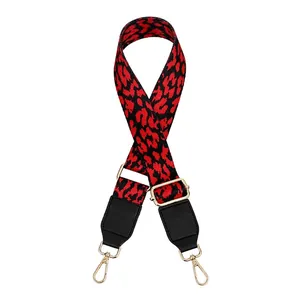 Detailed view of red and black leopard print wide bag strap with gold metal hooks